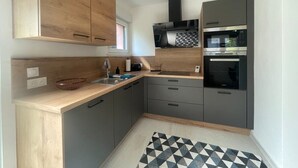 A compact kitchen with wooden cabinets, a microwave, and an oven.