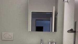 A compact bathroom with a toilet, sink, and mirror. - Perfect connected to Downtown, Airport & Highway (Basel)