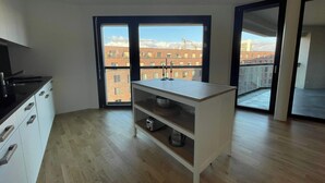 A modern apartment with a kitchen, a dining area, and a balcony with a city view. - Modern Apt. near City & Airport Basel (Basel)