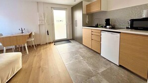 A modern kitchen with wooden cabinets, a white dishwasher, and a coffee maker.