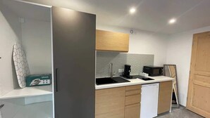 A modern kitchen with a built-in dishwasher, a microwave, and a coffee maker on the countertop.