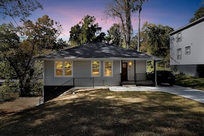 A single-story house with a front porch, a driveway, and a lawn. - Grove Park Haven Sleeps 12, Large Backyard (Atlanta)