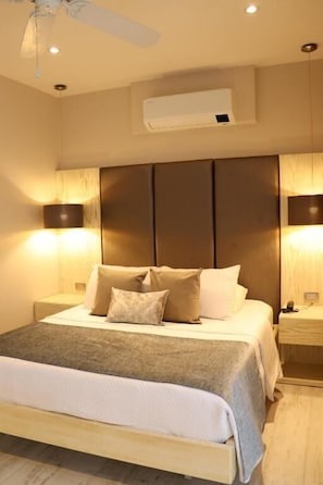 A hotel room with a bed, bedside lamps, an air conditioning unit, and a ceiling fan. - MATISIA HOTEL BOUTQUE (Guaduas)