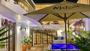A hotel patio with a pool, outdoor seating, and potted plants. - MATISIA HOTEL BOUTQUE (Guaduas)