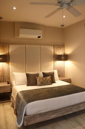 A bedroom with a bed, nightstands, a ceiling fan, and wall-mounted lighting. - MATISIA HOTEL BOUTQUE (Guaduas)