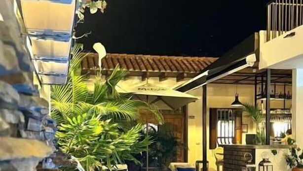 A swimming pool with a waterfall feature, surrounded by stone walls and tropical plants. - MATISIA HOTEL BOUTQUE (Guaduas)
