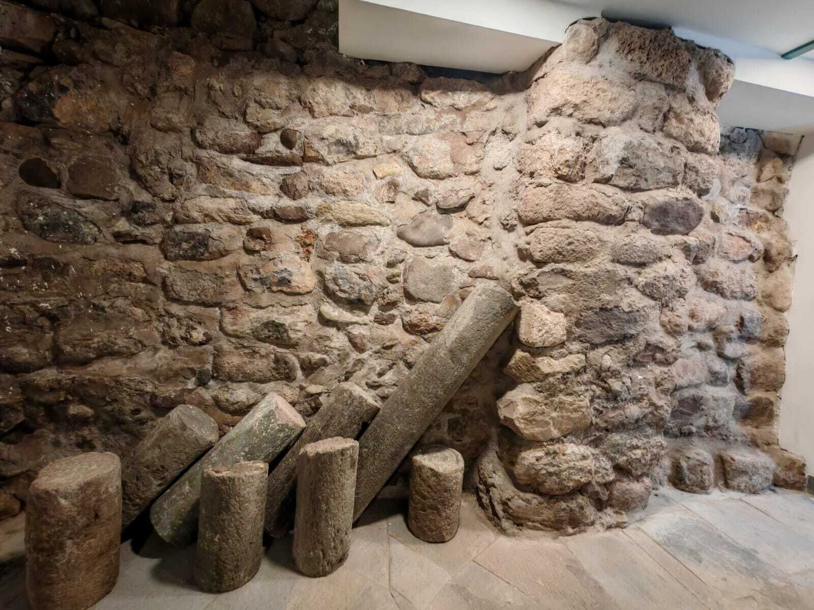 A stone wall with a rough texture and irregularly shaped stones.