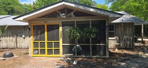 A small wooden structure with a yellow door, numbered 341, and a window with a plant inside. - New River Waterfront Dock  Kayak Launch + RV Hook up (Apalachicola)