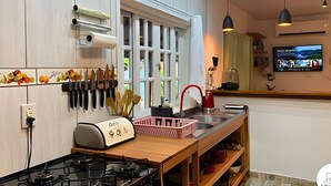 Une cuisine moderne équipée d’une cuisinière à gaz, d’un évier et d’une fenêtre.