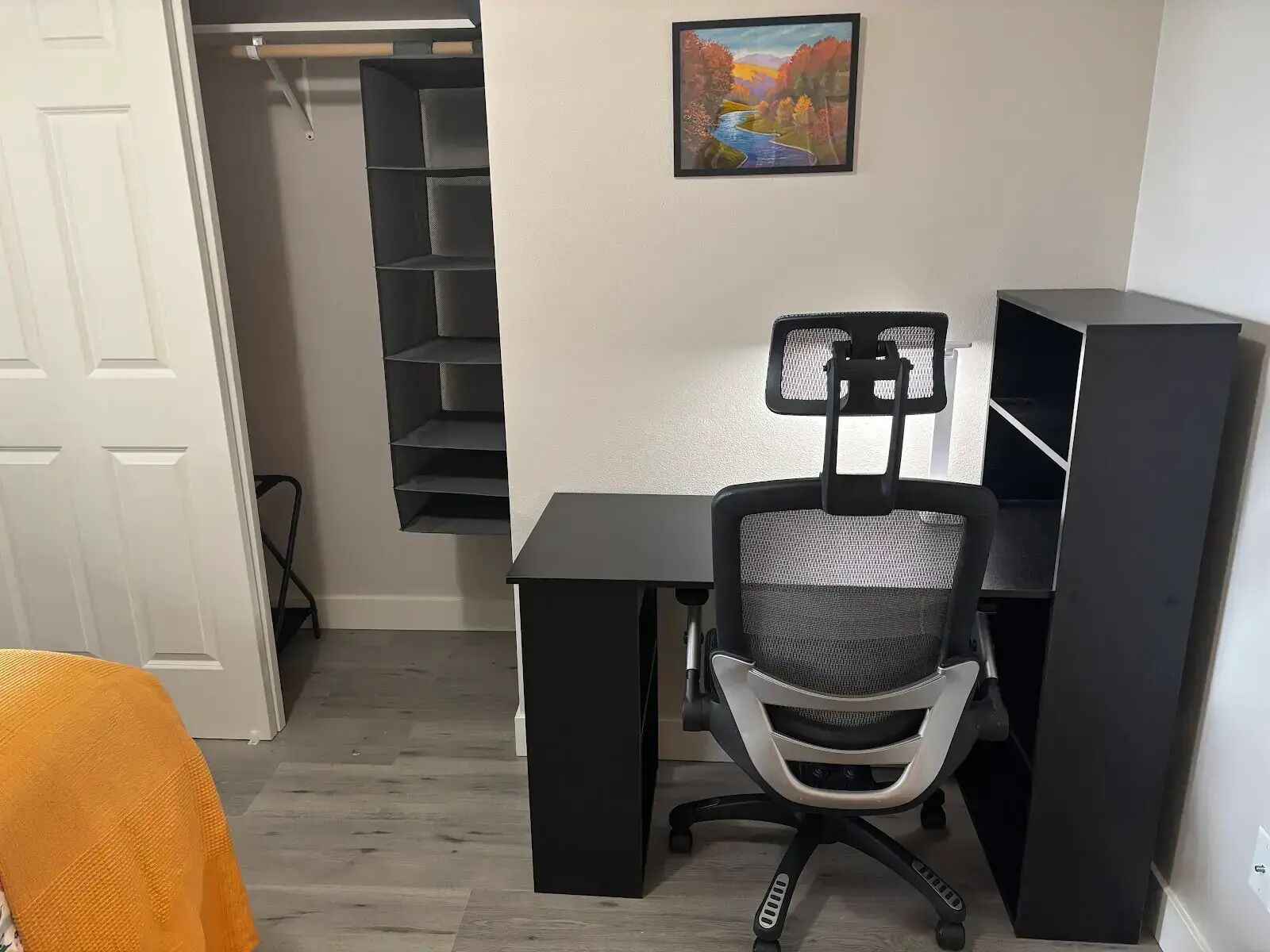 Un bureau à domicile comprenant un bureau, une chaise et une étagère.