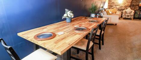 A dining area with a wooden table, six chairs, and a blue accent wall.