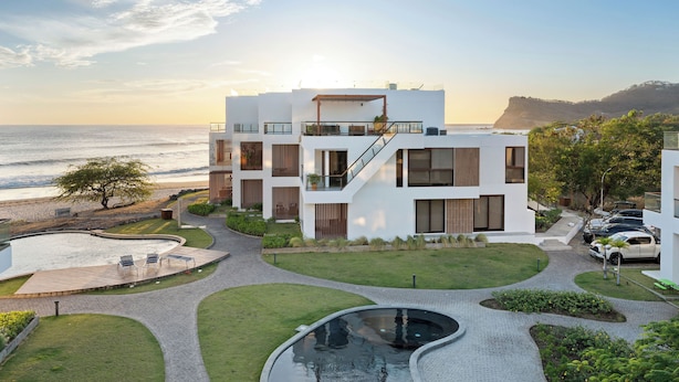 A modern building with a pool, a staircase, and a view of the ocean. - Hacienda Iguana 3BR Corner Rooftop- Costamar (Tola)