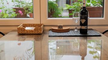 Una mesa con una botella de vino, una copa y un posavasos.