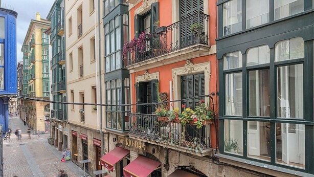 A street with buildings, some with balconies and outdoor seating. - Modern and Luxurious in Historic Old Town (Bilbao)