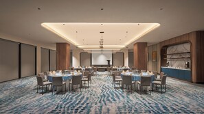 A conference room with a large table, chairs, a podium, and a screen. - Voco Kuching by IHG (Kuching)
