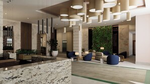 A modern lobby with a marble reception desk, multiple seating areas, and a vertical garden. - Holiday Inn Puerto Plata-Cofresi Bay Area By Ihg (Puerto Plata)