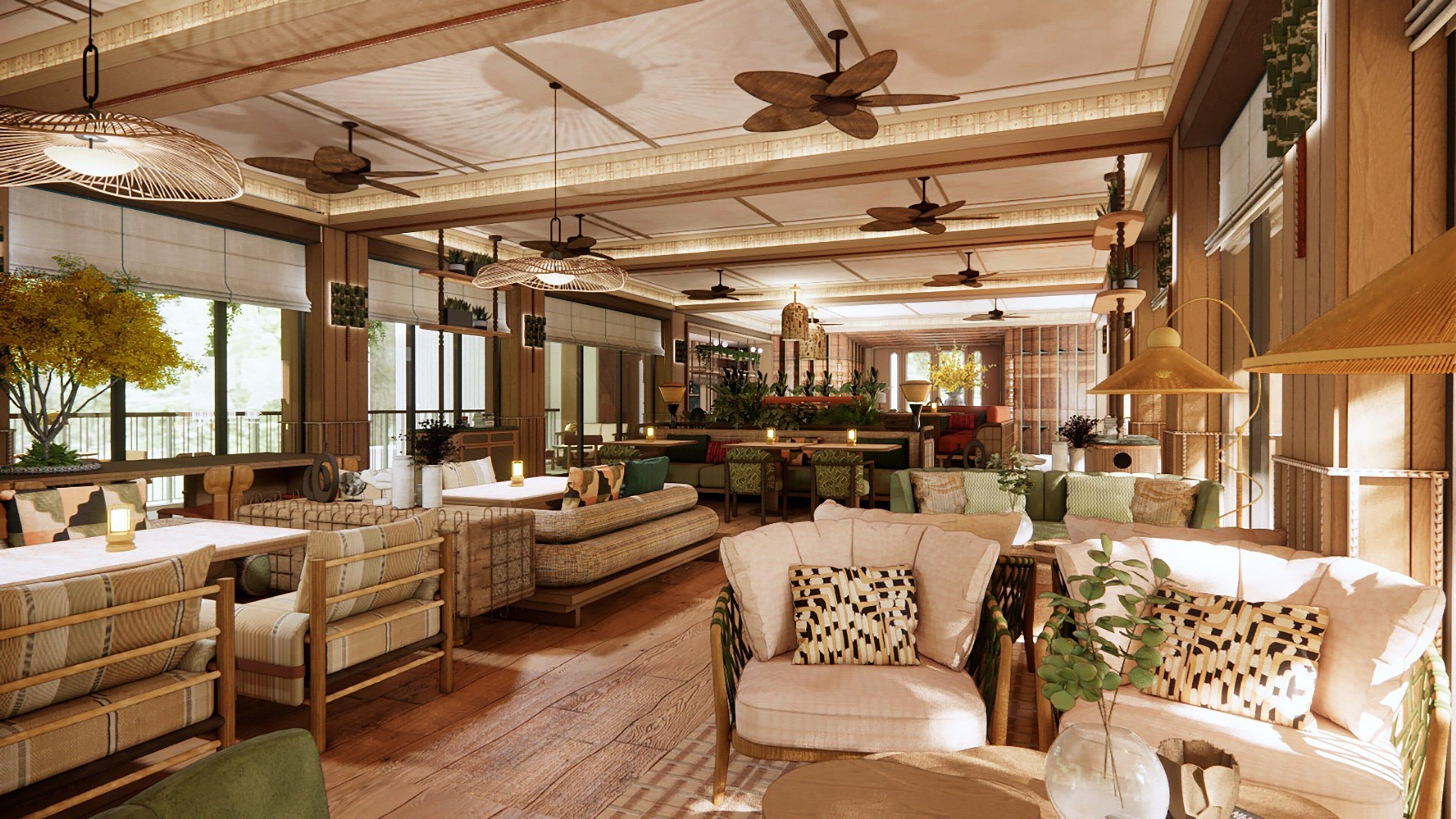 A spacious room with multiple seating areas, ceiling fans, and large windows allowing natural light.
