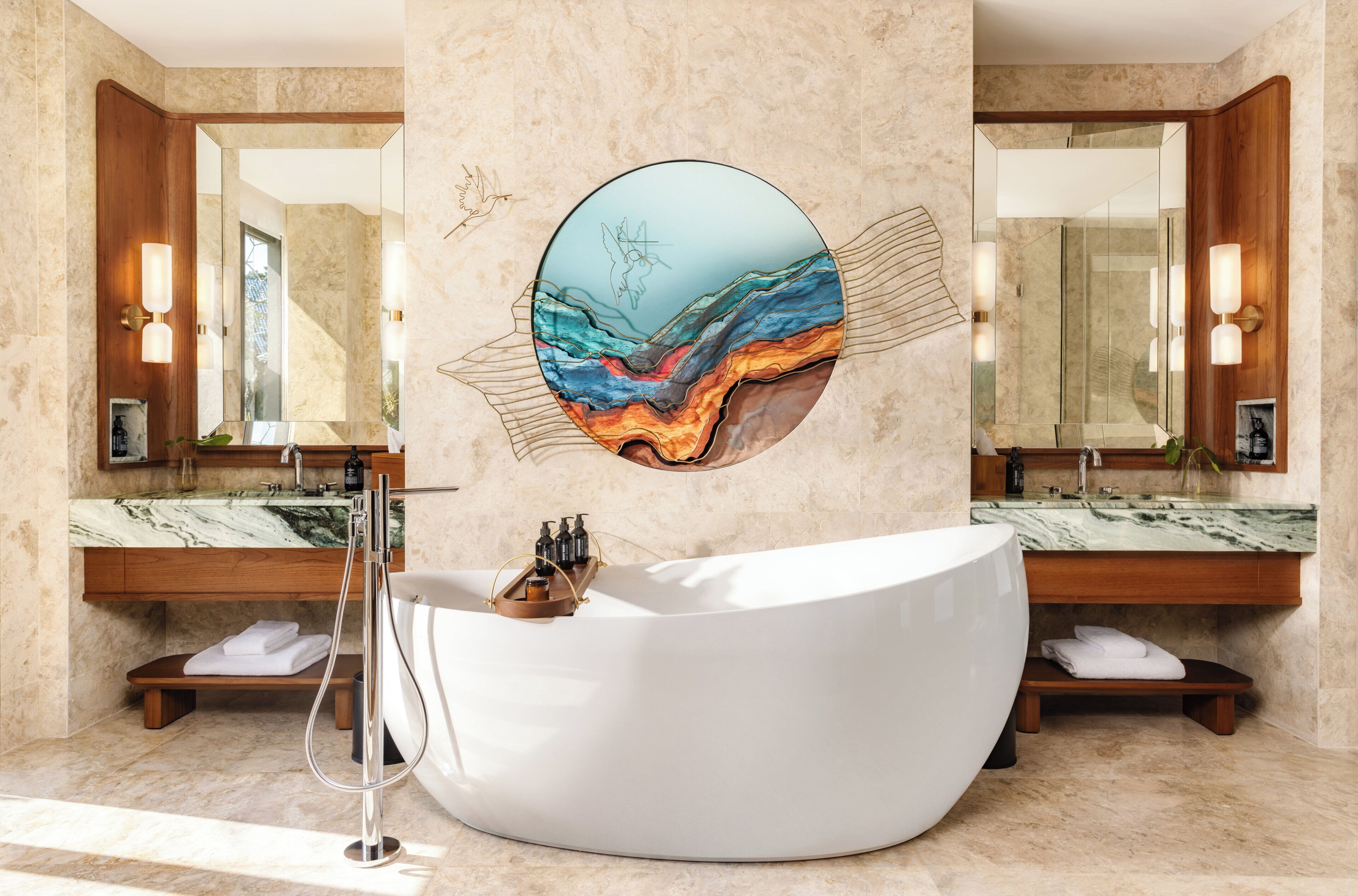 A modern bathroom with a large oval sink, marble countertops, and a wall-mounted mirror.