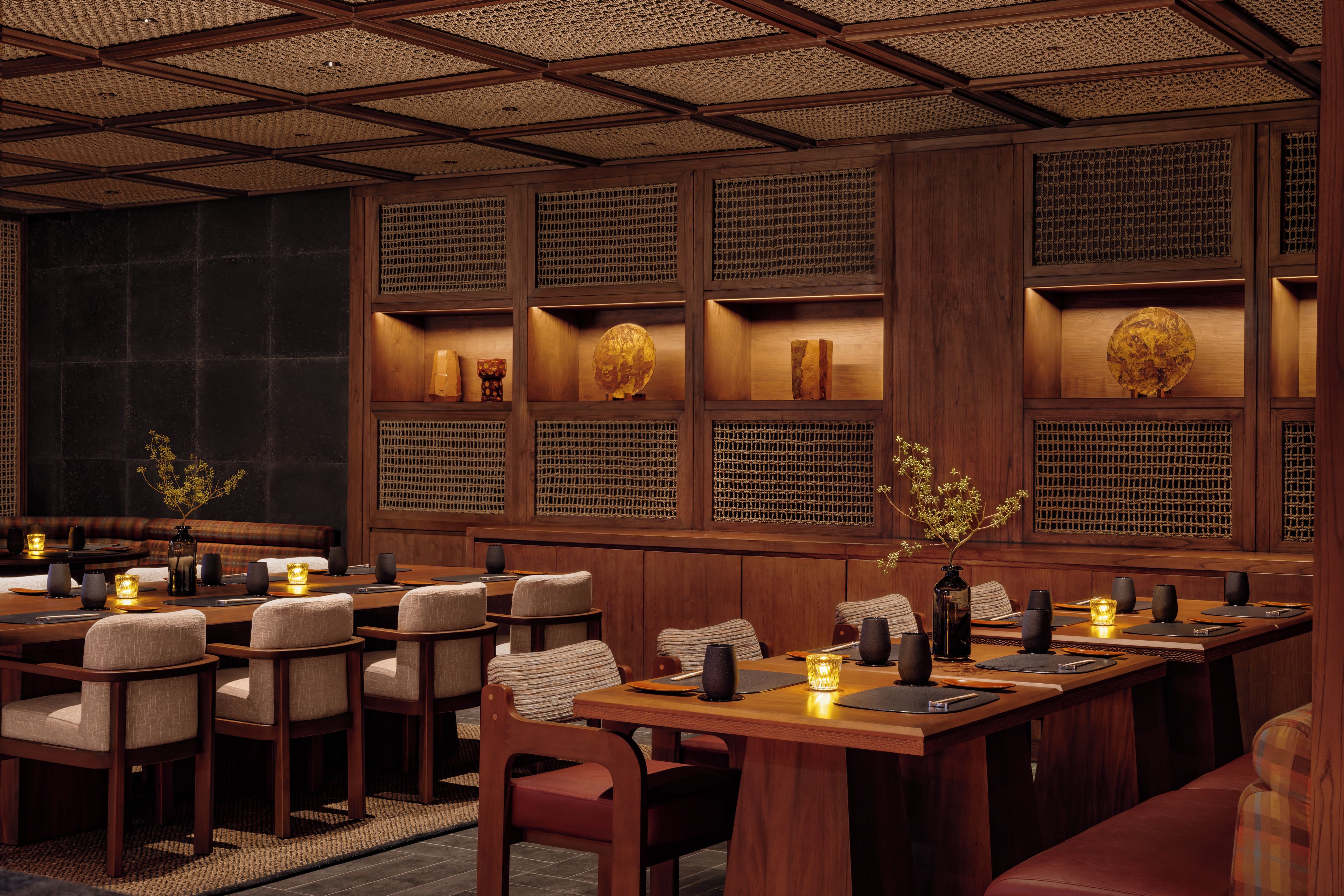A restaurant interior with wooden furniture, a patterned ceiling, and decorative wall panels.