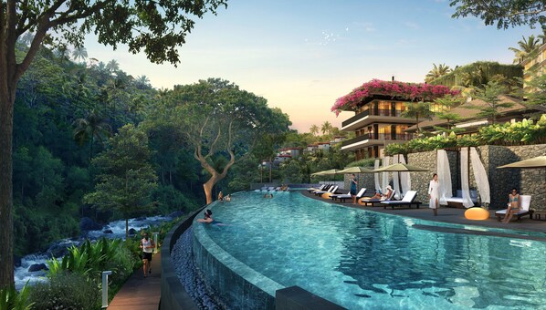 A resort pool with a wooden deck, lounge chairs, and a view of lush greenery and a mountain. - Kimpton Suntaya Bali Ubud by IHG (Ubud)