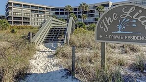 Ein privates Anwesen mit Zugang zum Strand, einer Treppe, die zu einem Gebäude führt, und einem Schild, das es als Privatbesitz kennzeichnet.