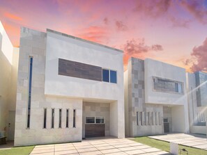 Un edificio moderno de dos pisos con techo plano, ventanas amplias y un diseño limpio y minimalista.