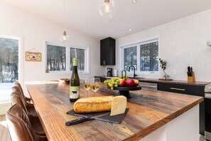Eine moderne Küche mit einer Holztheke, einer Weinflasche und Früchten.
