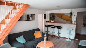 A modern living room with a sofa, a coffee table, and a staircase. - Surfbase Vieux Boucau (Vieux-Boucau-les-Bains)