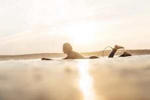 A person lying on a beach with a sunset in the background. - Surfbase Vieux Boucau (Vieux-Boucau-les-Bains)