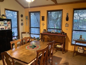 Comedor con mesa de madera, sillas y un mostrador tipo bufé.