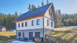 Un bâtiment à deux étages, doté de fondations en pierre, d’un toit en pente et d’une façade en bois.