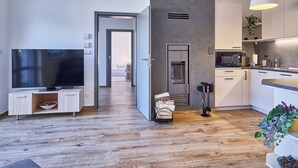 Une cuisine moderne dotée d’un four à micro-ondes encastré, d’une grande fenêtre et d’un coin repas avec une table et des chaises.