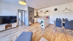 Un appartement moderne comprenant un salon, une cuisine, un coin repas et un téléviseur.