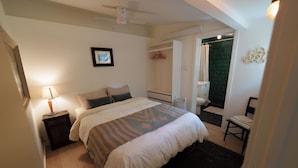 A bedroom with a bed, bedside table, lamp, and a view of the bathroom. - Cozy and private one-bedroom studio in Bishop (Bishop)