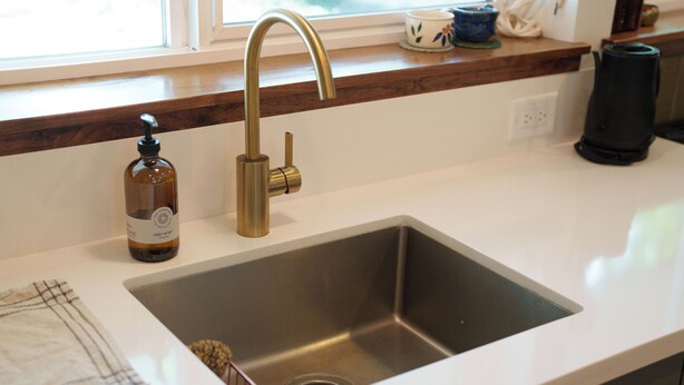 A kitchen with a stainless steel sink, a gold faucet, and a bottle of dish soap on the counter. - Cozy and private one-bedroom studio in Bishop (Bishop)