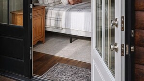 A bedroom with a bed, bedside table, lamp, and a framed quote on the wall. - Cozy 1-bedroom cabin in the Hocking Hills of Ohio (Londonderry)