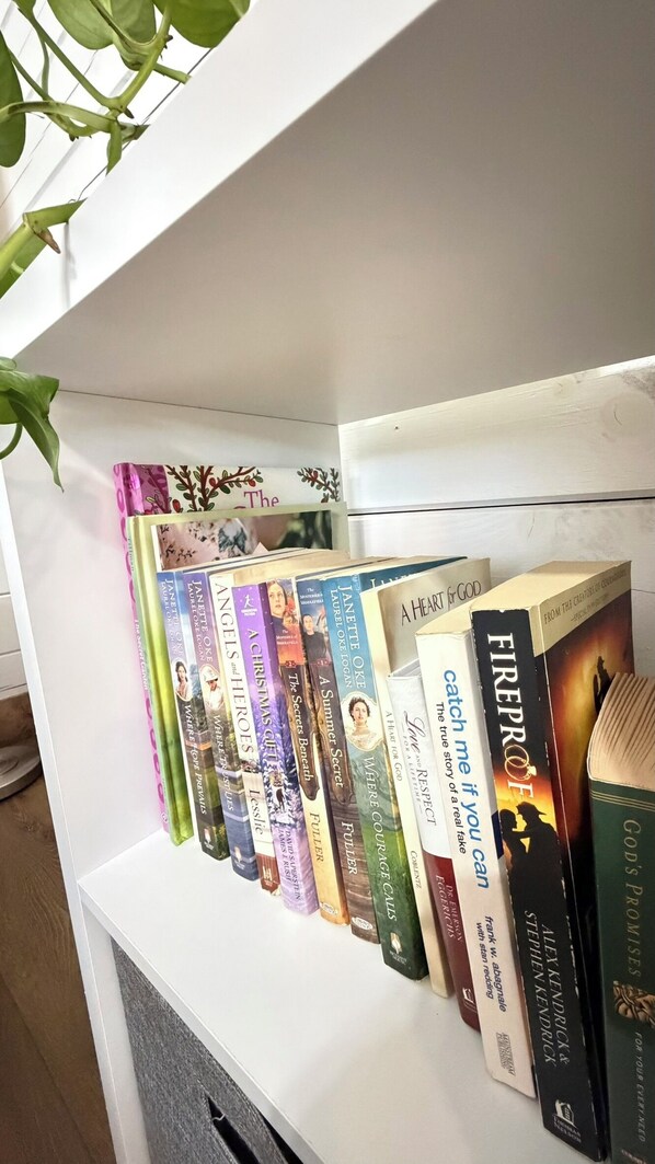 Una estantería con varios libros, algunos con títulos y autores visibles.