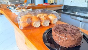 Un bufé de desayuno con pasteles y un pastel de chocolate sobre una mesa.