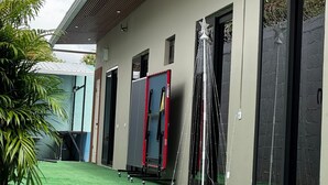 A modern building with a flat roof, large windows, and a green artificial turf lawn. - Villa Idalia (Comayagua)