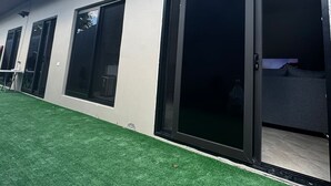 A modern building with large sliding glass doors, a flat roof, and a well-maintained lawn. - Villa Idalia (Comayagua)