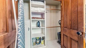 Um armário com prateleiras, barra para pendurar roupas e porta.