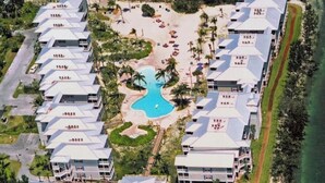 Ett hotellkomplex med flera byggnader, en central pool och ett område vid stranden.