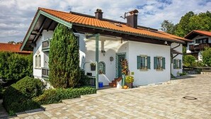 Een traditioneel huis met pannendak, een voortuin en een kleine tuin.