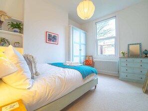 A bedroom with a bed, a dresser, a radiator, and a window with a view of trees. - Rosebay – Boutique Stay in Margate 2 beds nr Beach (Margate)