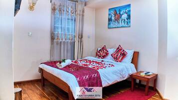 Une chambre à coucher avec un lit en bois, un plaid rouge et un tableau représentant des chevaux accroché au mur.