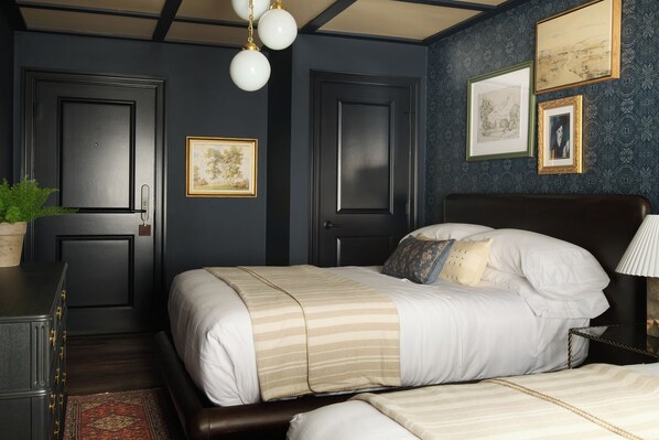 A bedroom with a bed, bedside tables, a lamp, and artwork on the wall.