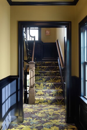 A staircase with a patterned carpet leading to a landing. - The Drew Hotel (Plymouth)