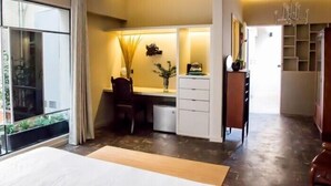 Ein modernes Schlafzimmer mit einem großen Bett, einem Schreibtisch und einem Stuhl. Es gibt einen Kleiderschrank und eine Chandelüster.