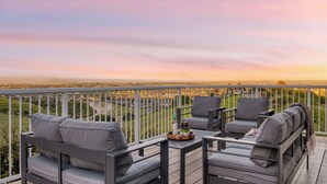 Ein Balkon mit Gartenmöbeln und Blick auf eine Stadtlandschaft.