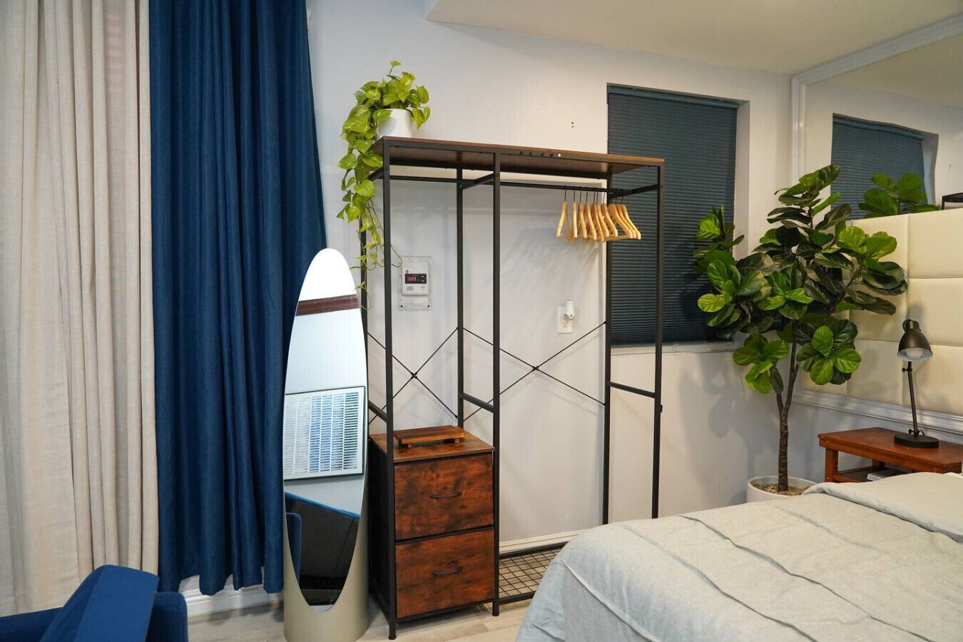 Une chambre à coucher avec un lit, une armoire, un bureau et une plante en pot.